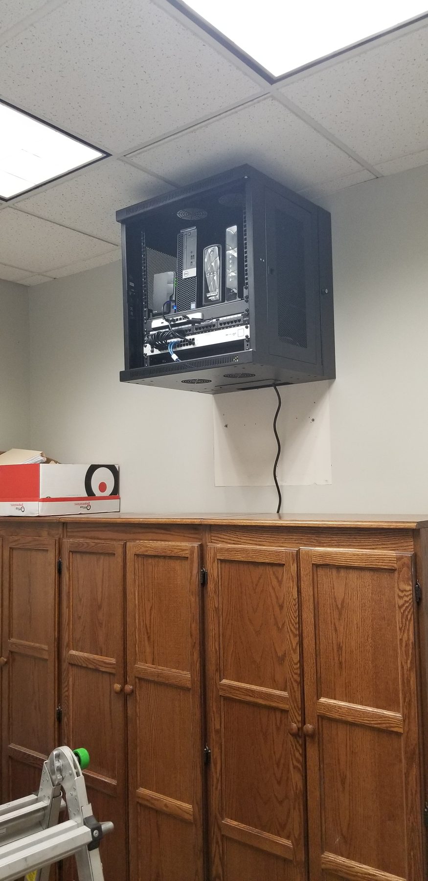 Wide view of a high-mounted network and storage cabinet in a commercial office