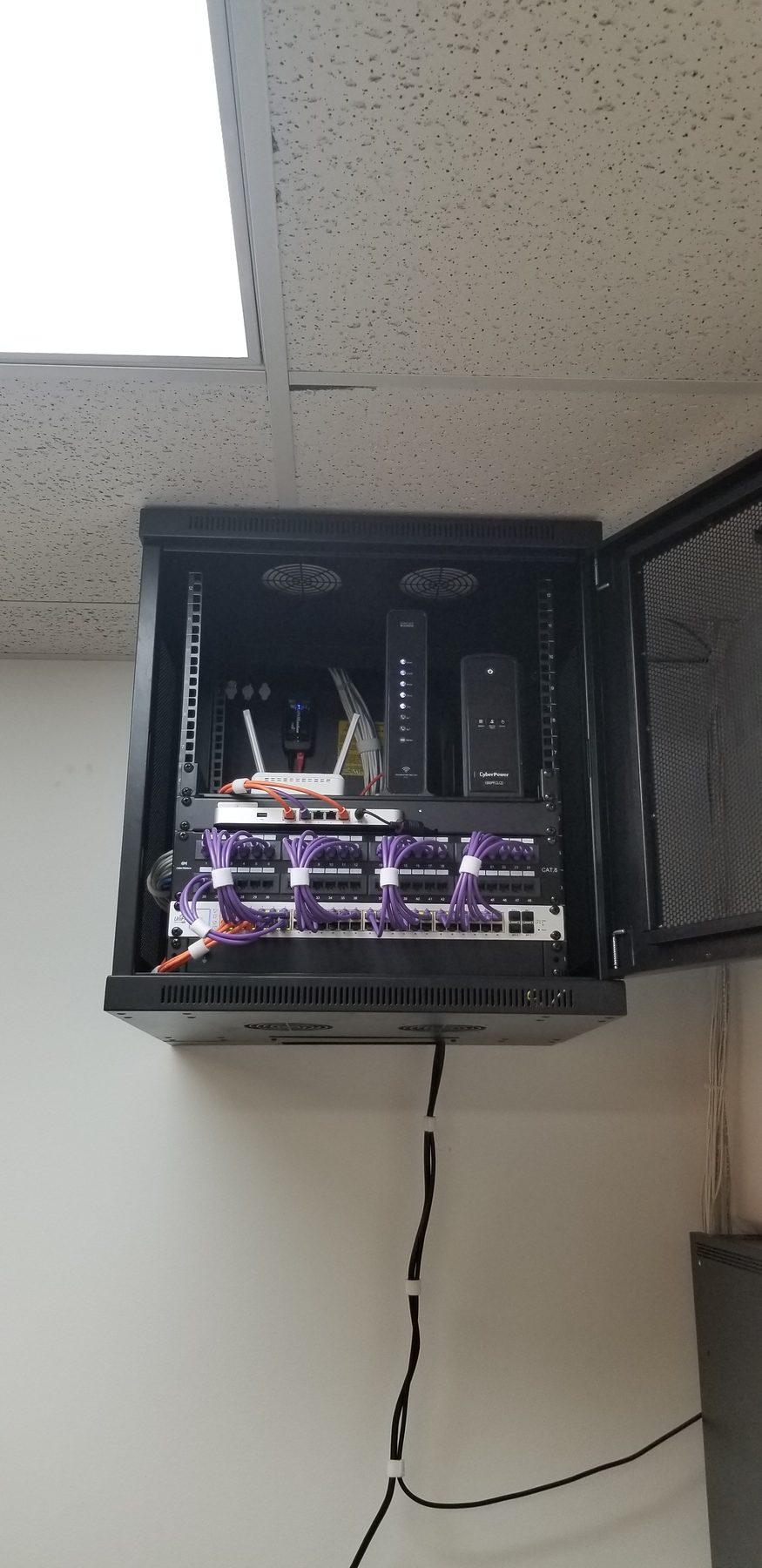 Open compact office network cabinet with patching, network equipment, and battery backup