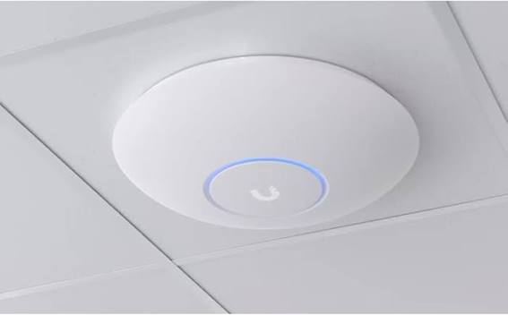Ubiquiti UniFi ceiling-mounted wireless access point with blue LED ring installed in a commercial office