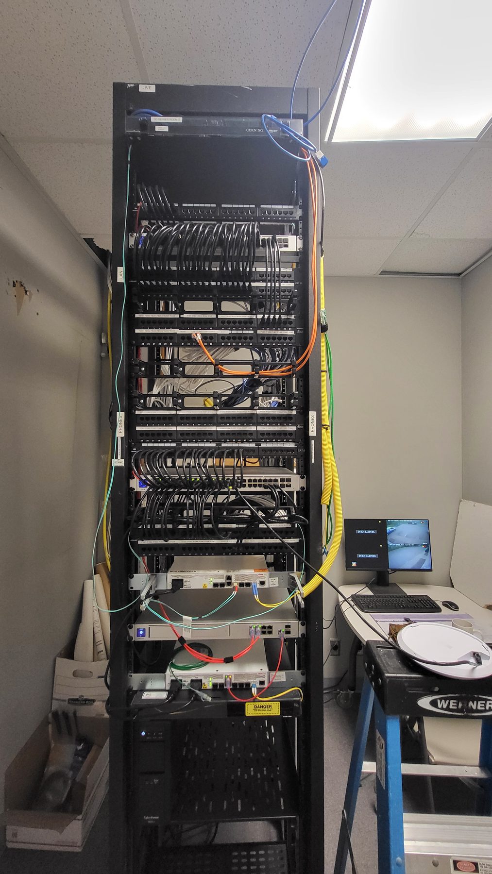 The same network rack after cleanup with patch cords cut to length and routed through vertical cable managers