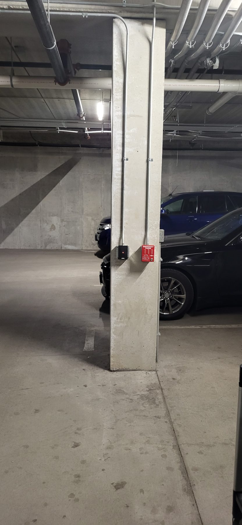 Parking garage column with a compact reader device mounted at eye level near a parked vehicle