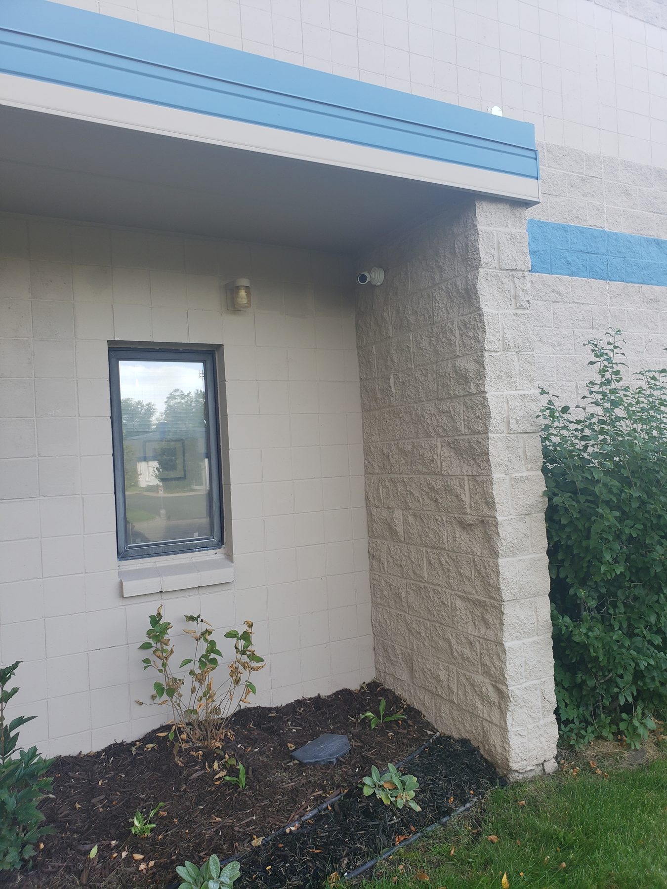 Recessed entry alcove with a camera mounted under the overhang above the window and door