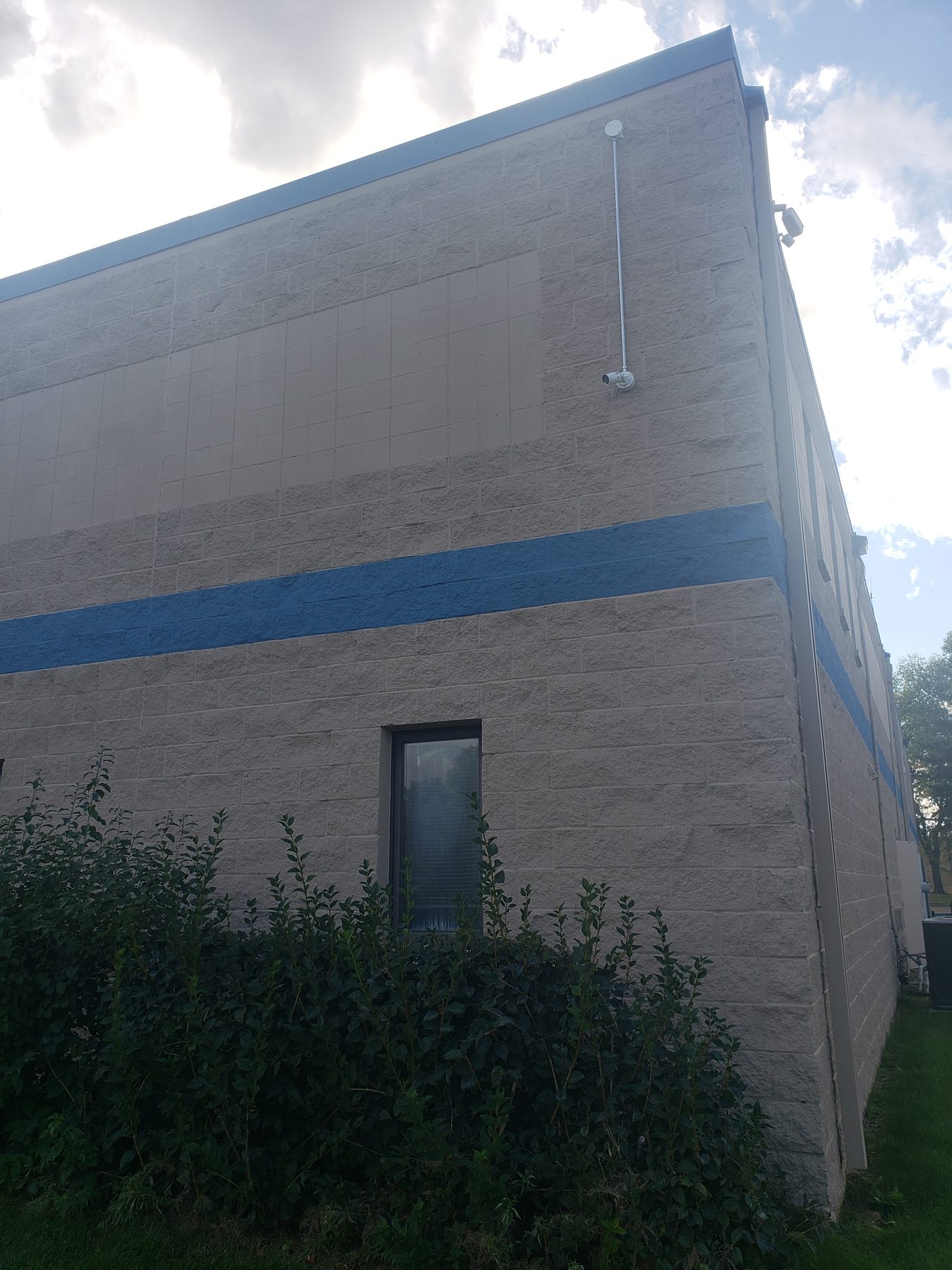 Upper corner of the building with a camera on an extension arm covering the rear elevation