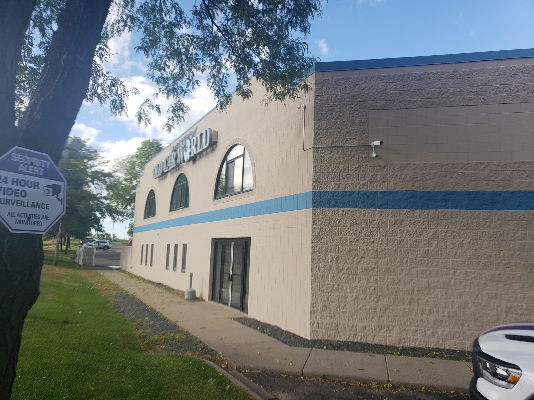 Wide view of the commercial building exterior with a security camera mounted high on the corner wall